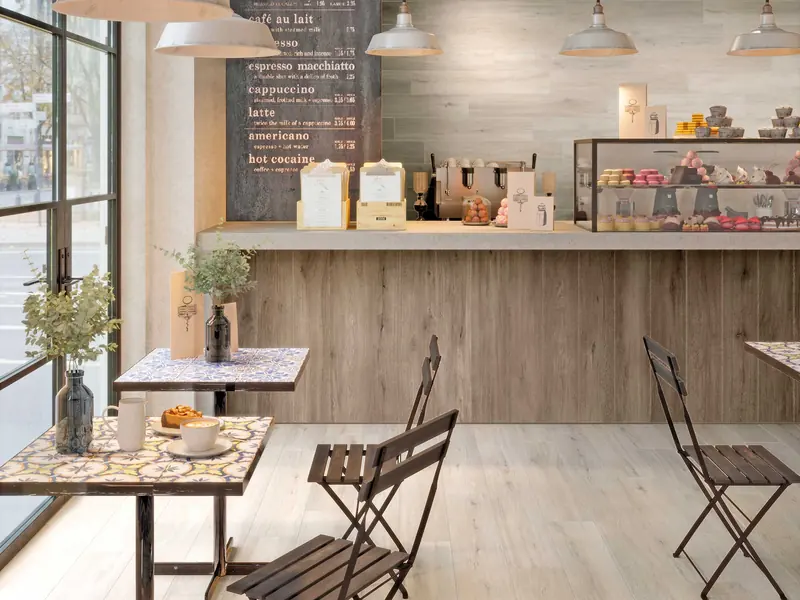 Cucina a vista di un locale con pavimento in gres porcellanato chiaro